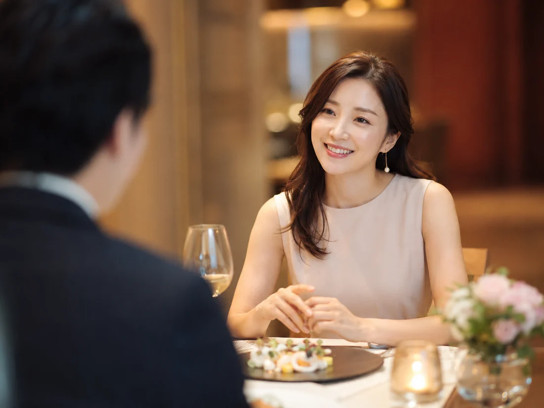 高級レストランで男性ゲストと会話を楽しみ微笑む女性