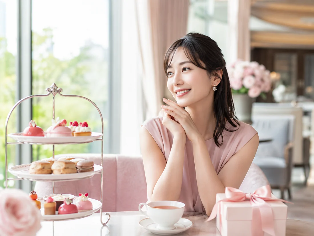 上品なカフェでアフタヌーンティーとギフトを楽しむ女性